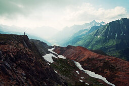 Hiker enjoying the view in the area of the Pfitscherjoch mountain pass, Pfitsch Valley in the background, South Tyrol, Italy