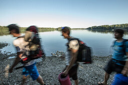 Three young male camper walking at a lake, Freilassing, Bavaria, Germany