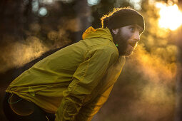 Junger Läufer macht eine kurze Pause in einem Wald, Allgäu, Bayern, Deutschland