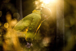 Young male runner having a short break in a forest, Allgaeu, Bavaria, Germany