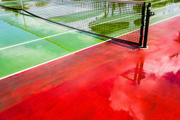 Rot und grün farbiger Tennishartplatz nach einem Regen mit Spiegelungen, Hamilton, Insel Bermuda, Großbritannien