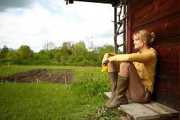 Woman with hawkbit in front of a wooden wall