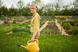 Woman with watering can in the garden