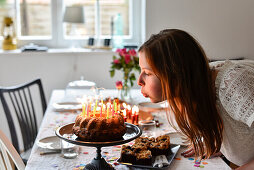 Mädchen pustet Kerzen auf Geburtstagskuchen bei Teenager Geburtstag von 14 jährigem Mädchen in Hamburg, Deutschland