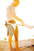 Young male windsurfer rigging up his sail on a sunny day, Ammersee, Bavaria, Germany