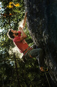 Young male climber blowing away the magnesium from his hand at a rock face, Schwaerzer Wand, Bavaria, Germany