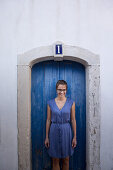 Young woman standing in front of a blue door, Sao Tome, Sao Tome and Principe, Africa