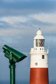 Ein Münzfernglas das Euro und Pfund akzeptiert vor dem Leuchtturm am Europa Point, Gibraltar, Großbritannien, UK