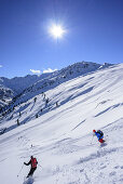 Zwei Personen auf Skitour fahren durch Pulverschnee vom Sonnenjoch ab, Sonnenjoch, Kitzbüheler Alpen, Tirol, Österreich