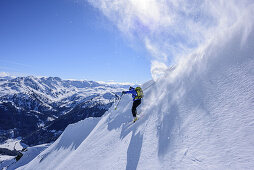 Person downhill skiing over cornice in the backcountry, Gamskopf, Kitzbuehel Alps, Tyrol, Austria