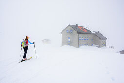 Frau auf Skitour geht durch Nebel zum Rifugio Ottone Brentari, Rifugio Ottone Brentari, Cima d' Asta, Fleimstaler Alpen, Dolomiten, UNESCO Weltnaturerbe Dolomiten, Trentino, Italien