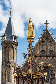 The statue on top of the golden fountain in the historical complex of buildings Binnenhof in the city centre, The Hague, Netherlands