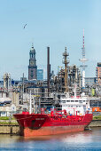 View at industrial plants in the Hamburg harbour with Michel and the television tower in the background, Hamburg, Germany