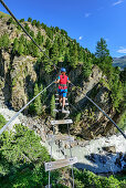 Frau überquert auf Hängebrücke Schlucht, Obergurgler Klettersteig, Obergurgl, Ötztaler Alpen, Tirol, Österreich