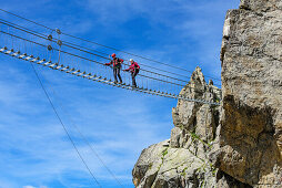 Man and woman climbing on fixed-rope Sentiero dei Fiori over big .. Bridge, Sentiero dei Fiori, Adamello-Presanella Group, Trentino, Italy