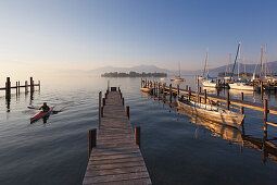 Bootsstege am Hafen, Blick über den Chiemsee zur Fraueninsel, bei Gstadt, Bayern, Deutschland