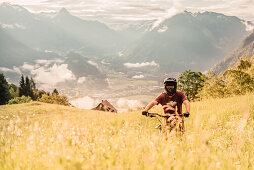 Mountainbiker in den Bergen bei Sonnenaufgang, Brandnertal, Vorarlberg, Österreich, Alpen, Berge, Bergab