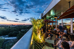 people at the terrace of the 25hours hotel and view to the Zoological Garden, Berlin, Germany