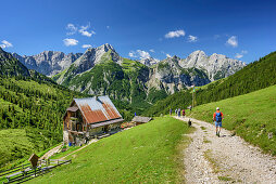 Several persons hiking towards hut Plumsjochhuette, Karwendel range in background, Plumsjoch, Mondscheinspitze, Natural Park Karwendel, Karwendel range, Tyrol, Austria