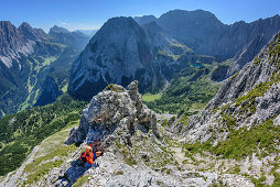 Woman hiking towards Ehrwalder Sonnenspitze, Mieming range in background, Ehrwalder Sonnenspitze, Mieming range, Tyrol, Austria