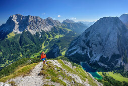 Frau beim Wandern steigt zur Ehrwalder Sonnenspitze auf, Wetterstein und Seebensee im Hintergrund, Ehrwalder Sonnenspitze, Mieminger Berge, Tirol, Österreich