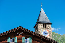 An old timber house and the church in the village center, Saas im Praettigau, Klosters, Grisons, Switzerland