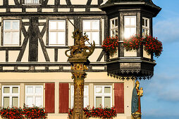 Oriel of the Jagstheimerhaus house on the town hall square with the market fountain, Rothenburg ob der Tauber, Bavaria, Germany