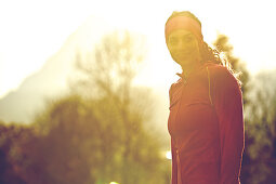 Young female runner outside in the nature on a sunny day, Fuessen, Bavaria, Germany
