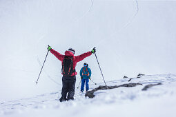 Junger Skifahrer jubelt zu seinem fahrenden Freund, Gudauri, Mzcheta-Mtianeti, Georgien