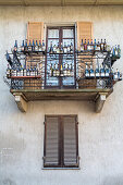 empty wine bottles decorate a balcony, Piedmont, Italy