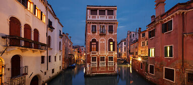 Panorama mit Blick auf ein beleuchtetes Haus zwischen den Kanälen Rio di San Giovanni Laterano und Rio de la Tetta im Blau der Dämmerung, Castello, Venedig, Venezien, Italien
