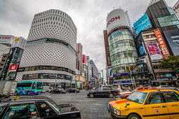 Kreuzung mit Autos am Ginza Place und Ricoh Imaging Square an wolkigem Tag, Chuo-ku, Tokio, Japan