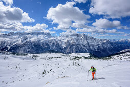 Woman backcountry skiing ascending towards Forca del Palone, Kanin group in background, Forca del Palone, Julian Alps, Friaul, Italy