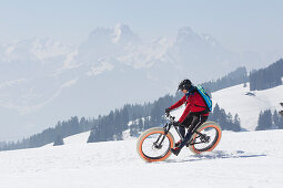 Ein junger Mann auf einem Fatbike, Snowbike, Mountainbike bei Sparenmoos oberhalb von Gstaad, Berner Oberland, Schweiz