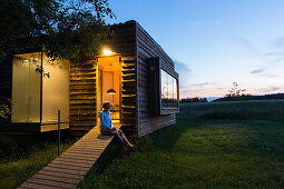 Frau vor Bungalow, Rehof Rutenberg, von holländischen Künstlern liebevoll sanierter alter Pfarrhof, Ferienwohnungen und Gartenhäuser, Sauna, Design, Architektur, gelegen an der Grenze von Mecklenburg-Vorpommern und Brandenburg, Mecklenburgische Seen, Meck