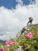 Junge Wanderin steht auf einem Felsen in der Nähe des Muttlerkopf in den Alpen
