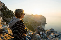 Frau schaut Sonnenuntergang, Kap Formentor, Port de Pollença, Serra de Tramuntana, Mallorca, Balearen, Spanien