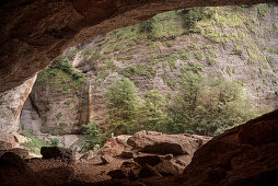 ' hiker sits inside the natural wonder called ''Ofenloch'', canton St. Gallen, Switzerland, Europe'