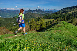 Woman trail running crossing ridge, Kaiser range in background, Mitterberg, Bavarian Alps, Upper Bavaria, Bavaria, Germany