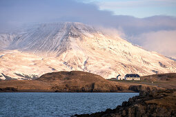 Verschneite Landschaft an der Küste nahe Reykjavik mit Blick auf das Gebirge Esja in Wolken, Reykjavik, Island, Iceland, Europa