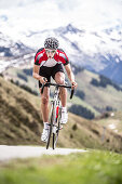 Young man on his racing cycle at the Kitzbühler Alps, Kitzbühlerhorn, Tyrol, Austria
