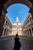 Eine Touristin schießt ein Foto vom  Innenhof der barocken Kirche Sant'Ivo alla Sapienza, Rom, Latium, Italien