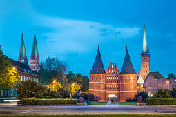 Illuminated Holstentor, St. Marien and St. Petri church, Luebeck, Baltic coast, Schleswig-Holstein, Germany