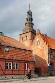 Cyclist in front of church St. Maria Kyrkan, Ystad, Skane, Southern Sweden, Sweden