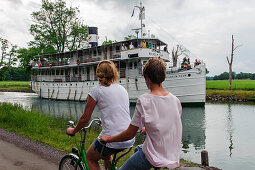 Tandemfahrer vor Dampfschiff Wilhem Tham auf dem Goetakanal zwischen Borensberg und Berg Slussar , Schweden