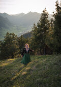 Young woman in traditional costume hiking on the Falkenstein in the Allgaeu, Pfronten, Bavaria, Germany