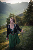 Junge Frau in Tracht wandert auf dem Falkenstein im Allgäu, Pfronten, Bayern, Deutschland