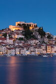 Beleuchtete Festung St. Michael und Häuser am Wasser in der Abenddämmerung, Šibenik, Šibenik-Knin, Kroatien, Europa
