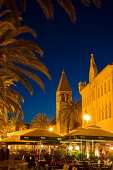 People at outdoor restaurants with church tower in Old Town at dusk, Trogir, Split-Dalmatia, Croatia