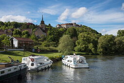 Le Boat Magnifique houseboat during cruise on Petit Saône river approaches mooring pier with Château Ray-sur-Saône castle behind, Ray-sur-Saône, Haute-Saône, Bourgogne-Franche-Comté, France